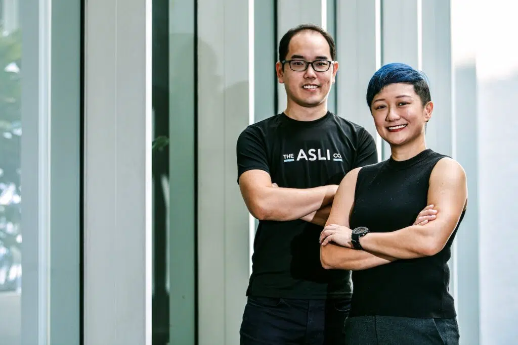 Jason Wee and Lim Xin Yu standing with folded arms outside a modern building
