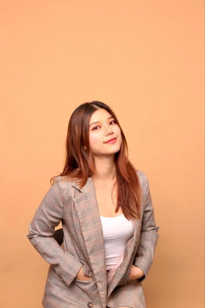 Ivor Lim in a checked blazer against a warm neutral studio background.