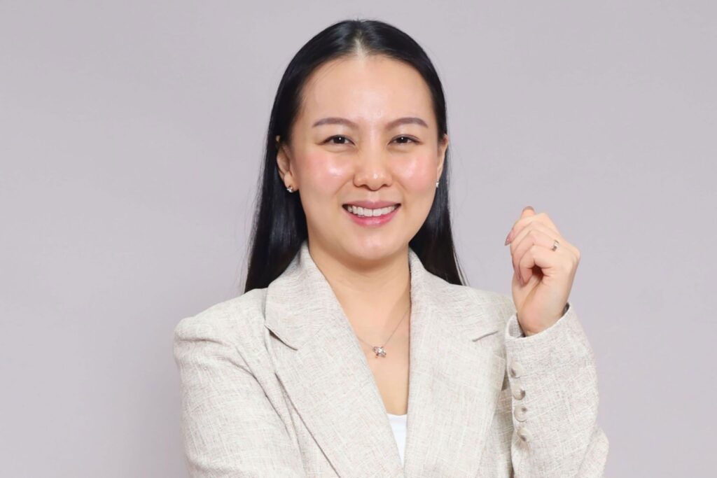 Lee Hui Jing in a light grey blazer against a clean studio background.