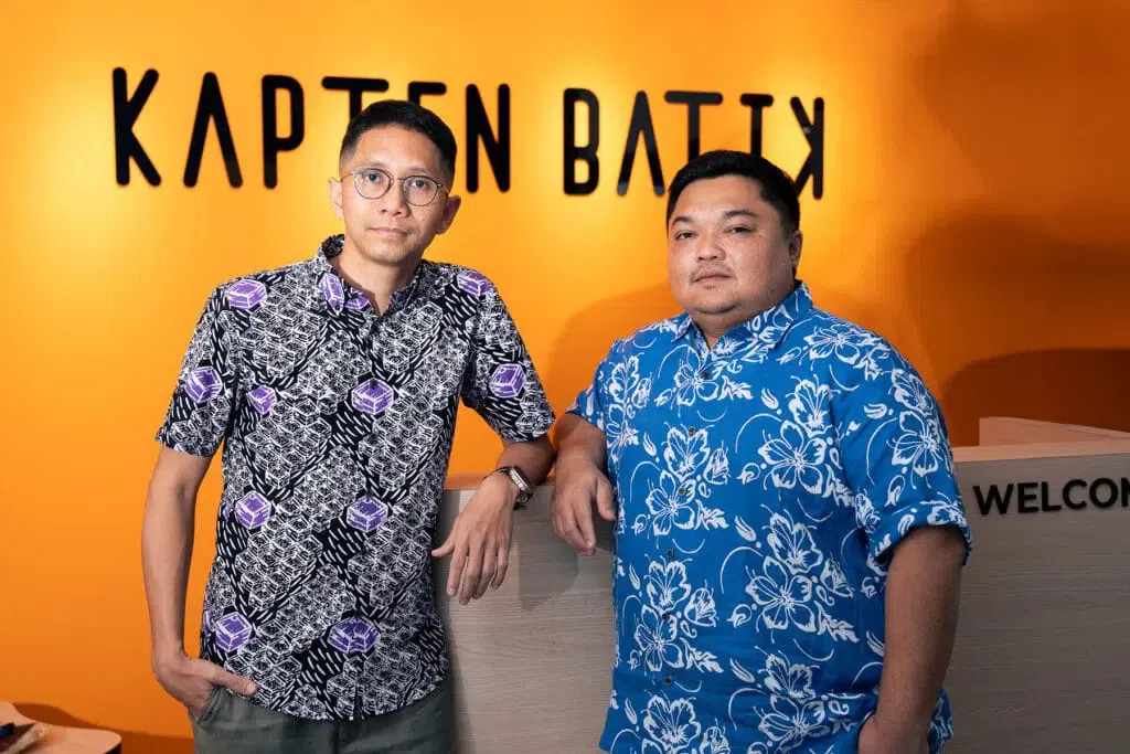 Ekram Faiz and Farhan Omar standing at a reception counter beneath Kapten Batik signage