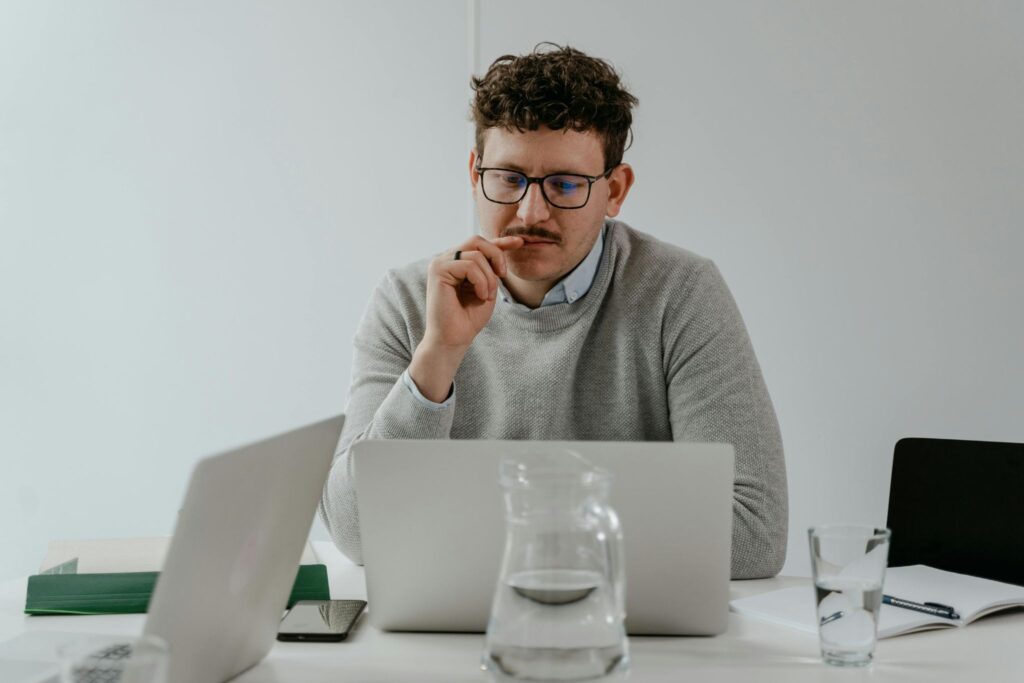 Male entrepreneur working on a laptop at a desk in a bright minimalist office