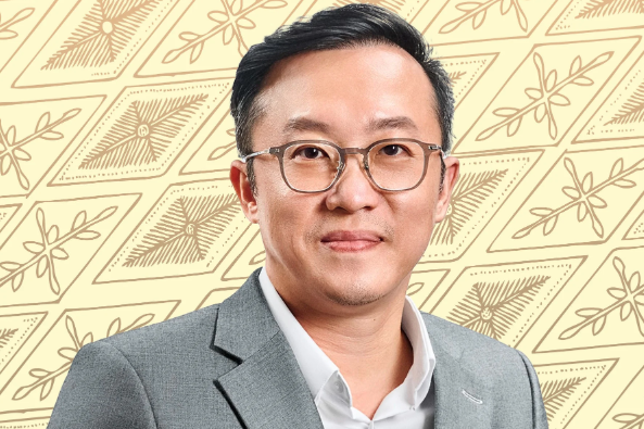 davis chong, Executive Director and Group CEO of Solarvest Holdings Berhad, wearing glasses and a suit stands confidently in front of a colorful patterned background.